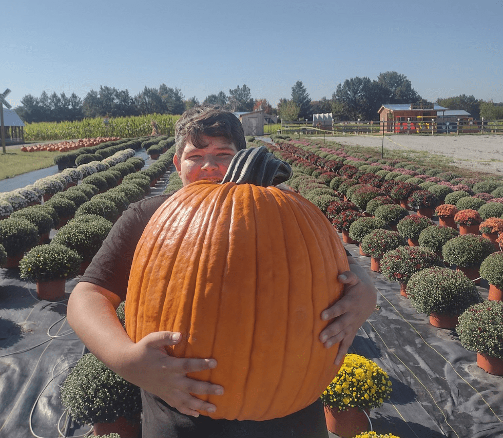 a boy with a big pumkin